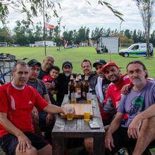 Dos trabajadores de la construcción construyen un marco de techo de madera al aire libre en un día soleado.