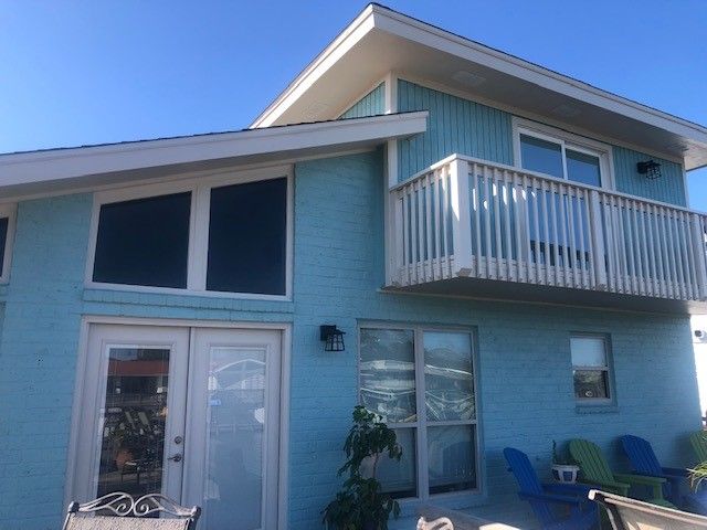 a blue house with a balcony on the second floor | Corpus Christi, TX | GT Roofing