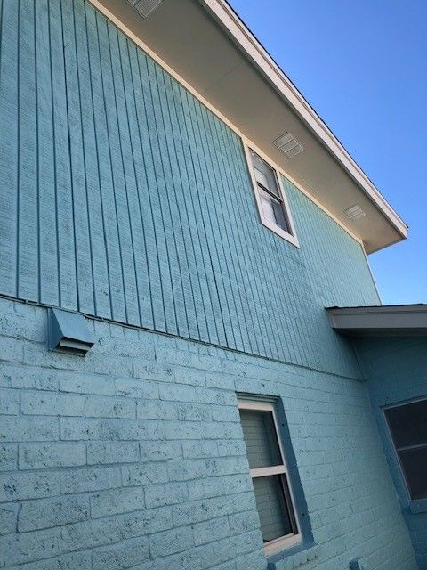 a blue brick building with a window on the side | Corpus Christi, TX | GT Roofing