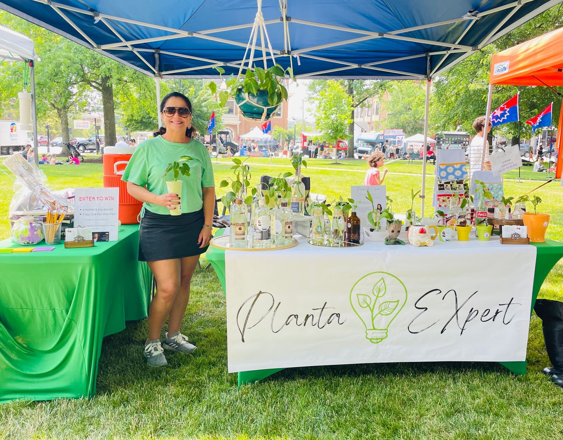 A woman is standing in front of a table with a sign that says planta expert.