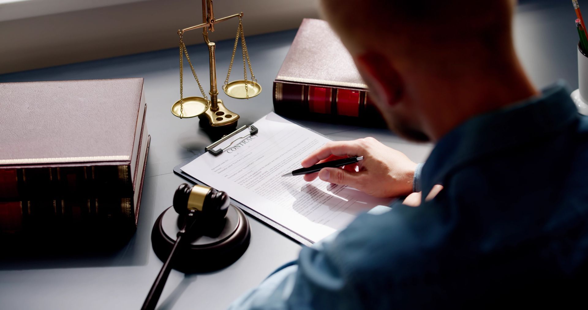 Person pointing to a document during a meeting, likely signing a contract.