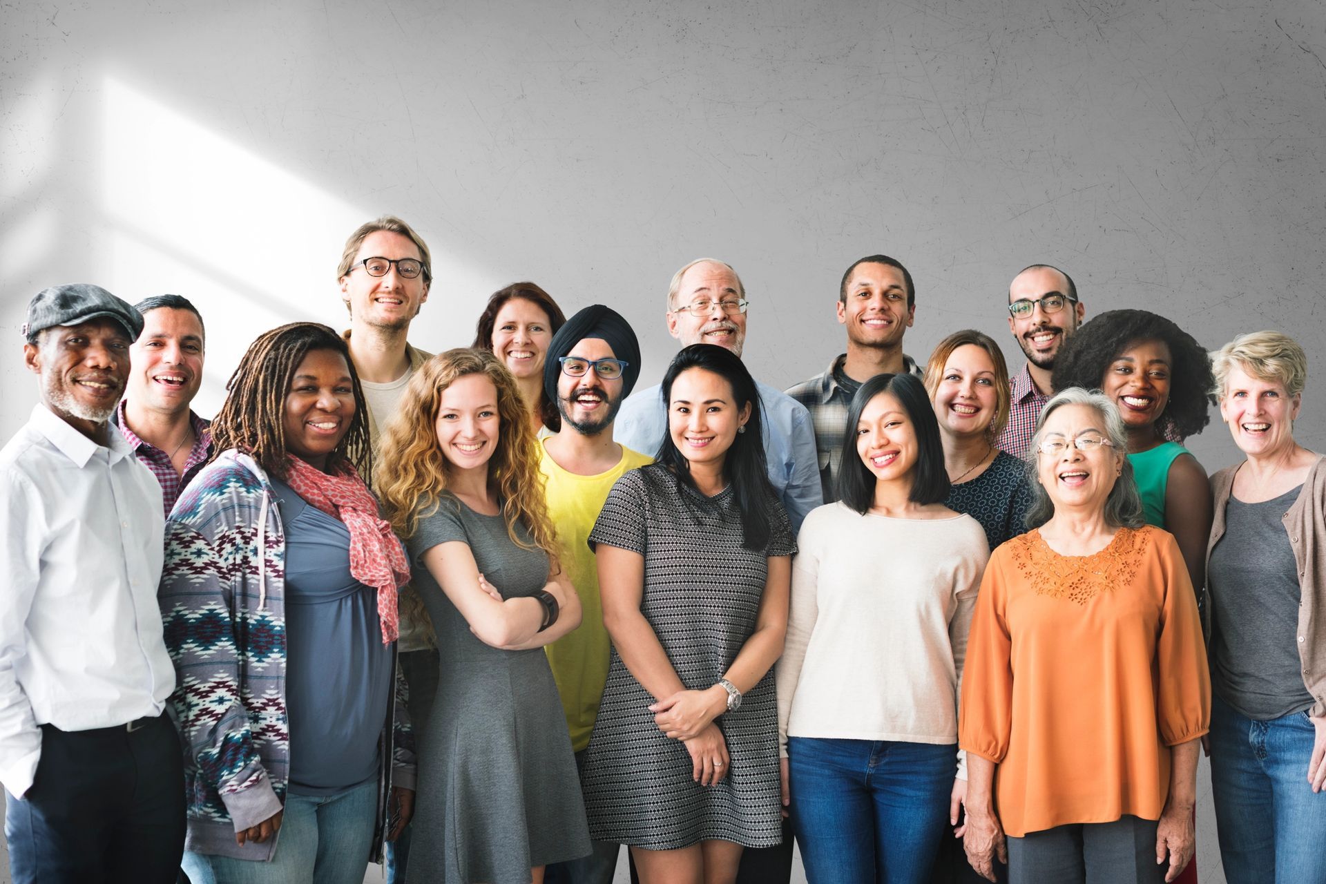 A person in a suit sits at a desk with law books, scales of justice, and documents while holding a pen.