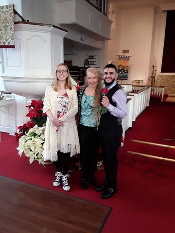 A man and two women are posing for a picture in a church.