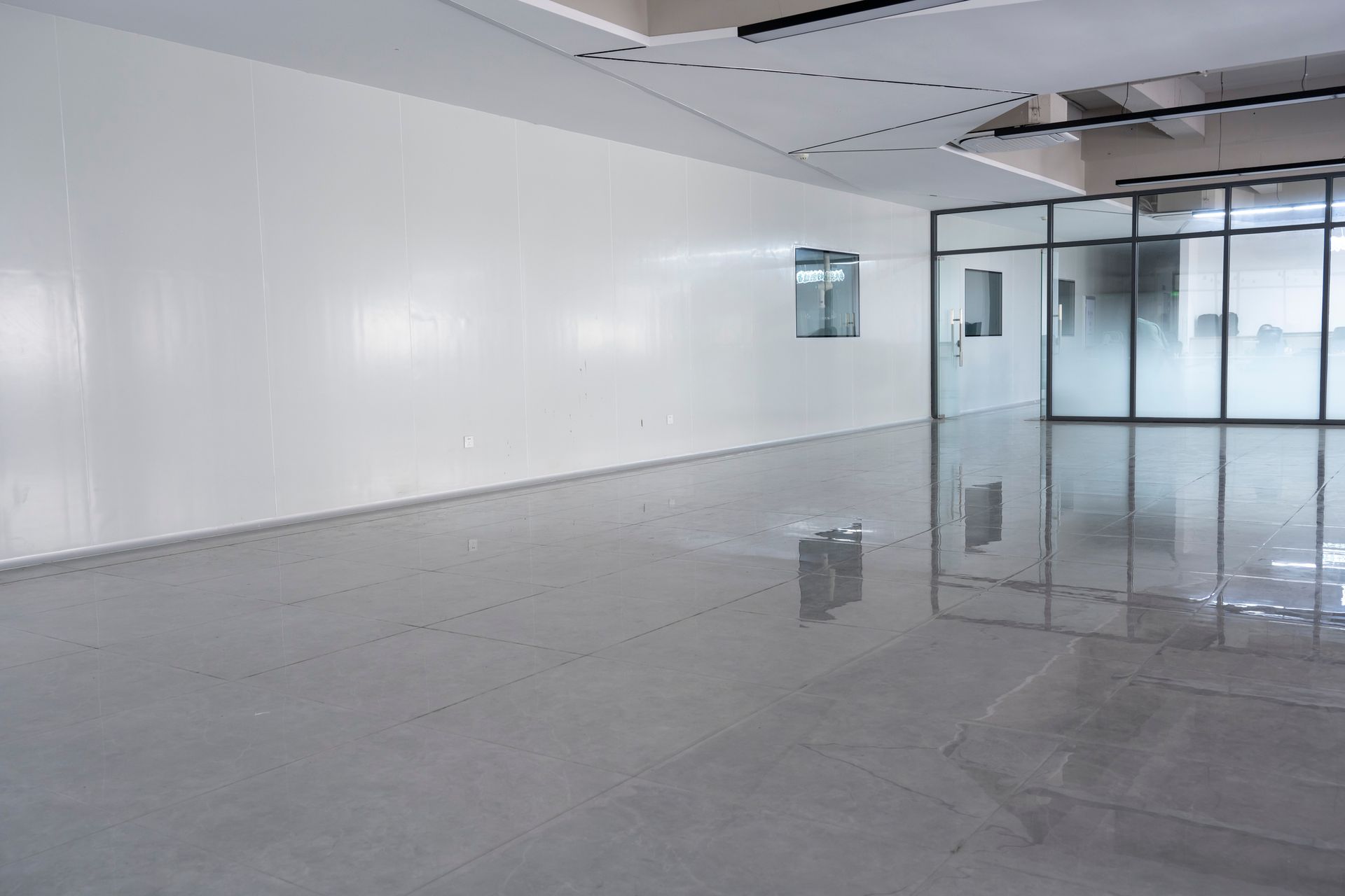 A large empty room with white walls and a shiny floor.