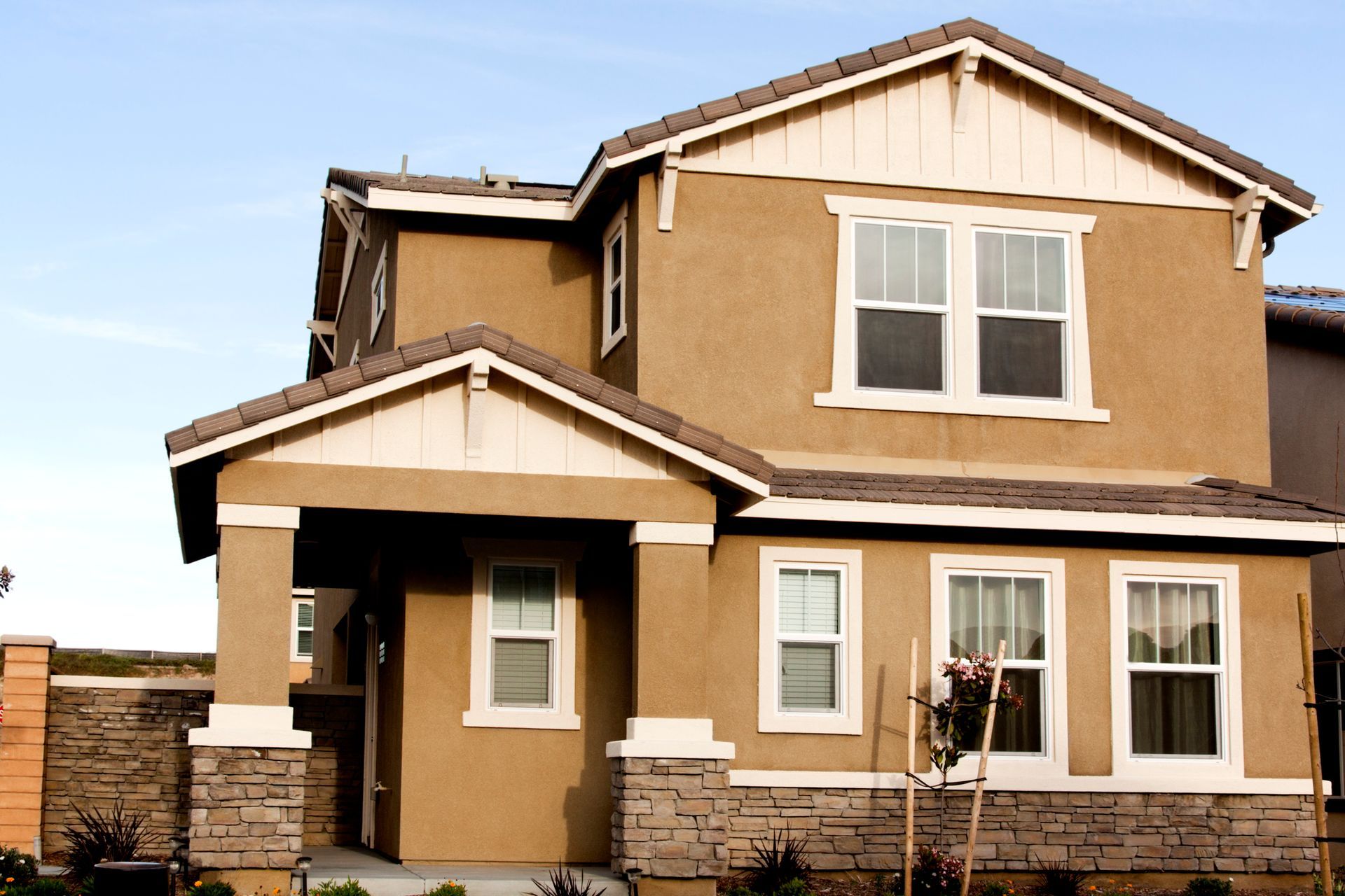 A house with a lot of windows and a blue sky in the background