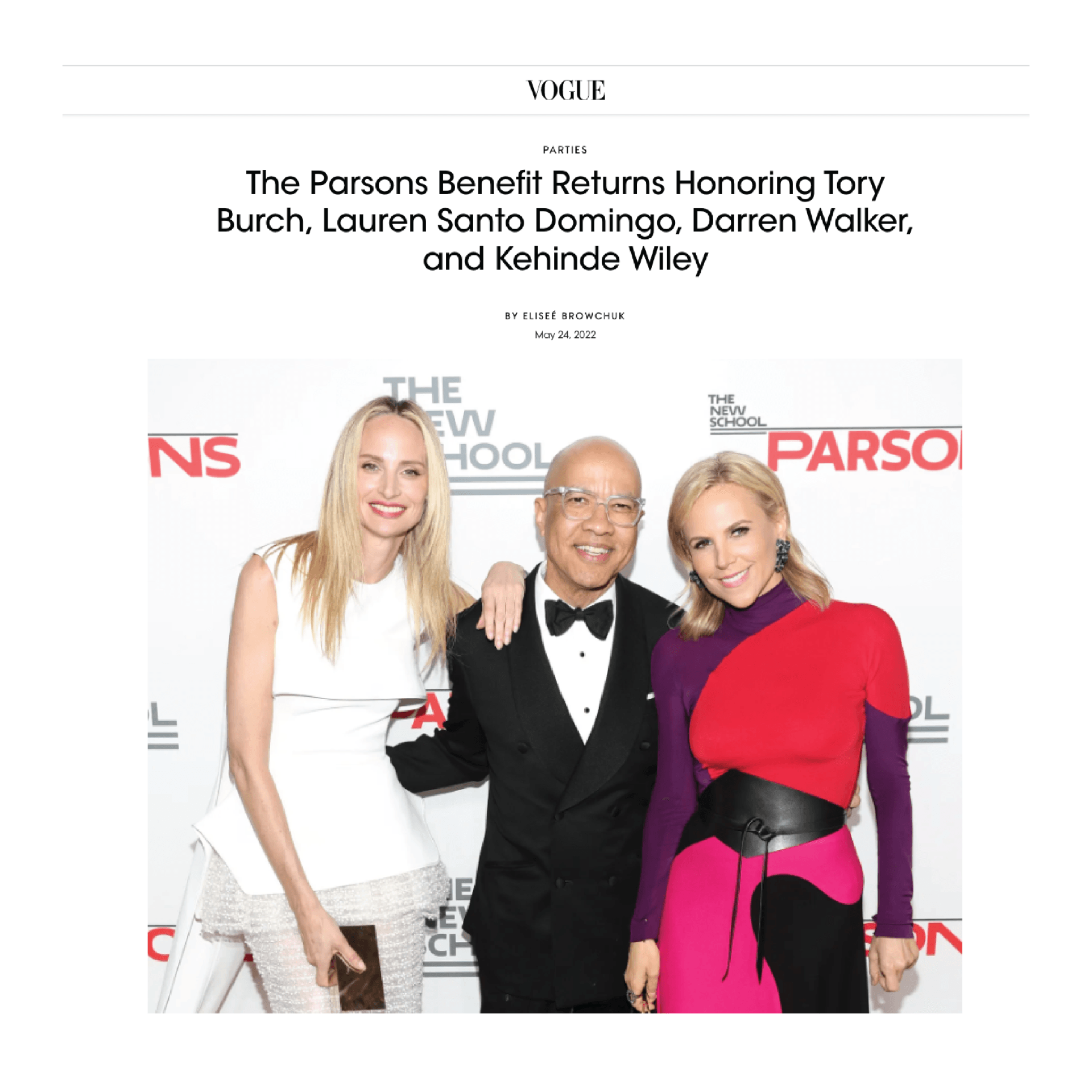 A group of people standing next to each other on a red carpet.