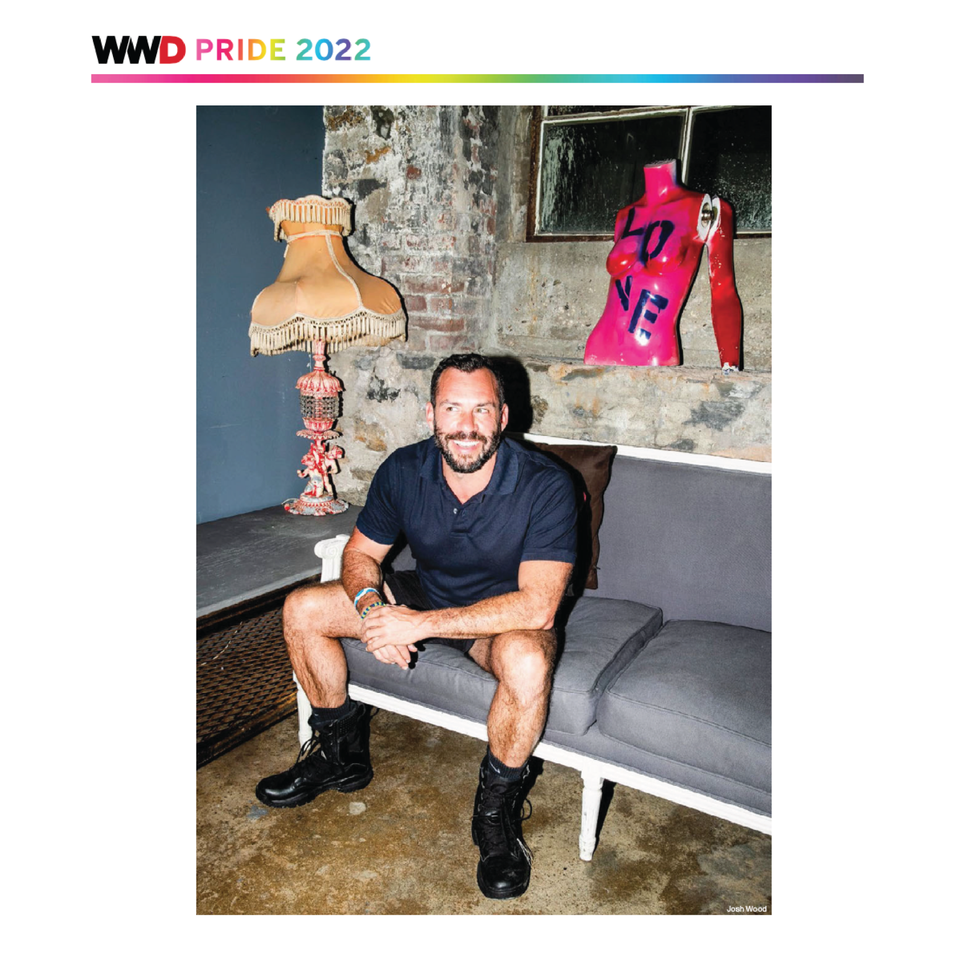 A man is sitting on a couch in front of a lamp.