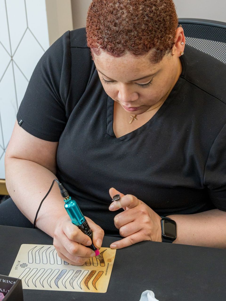 A woman in a black shirt is writing on a piece of paper