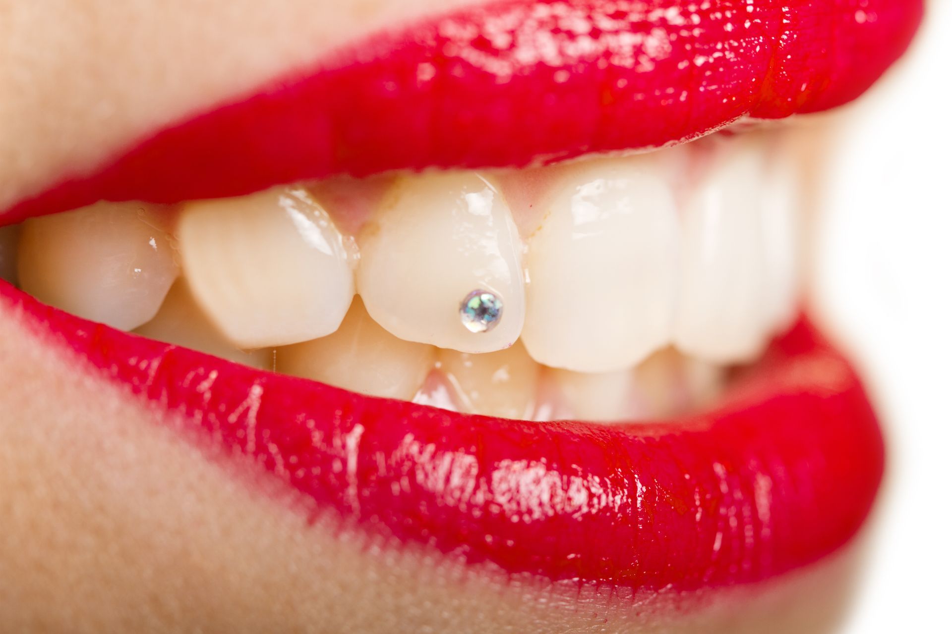 A close up of a woman 's mouth with a diamond in it.