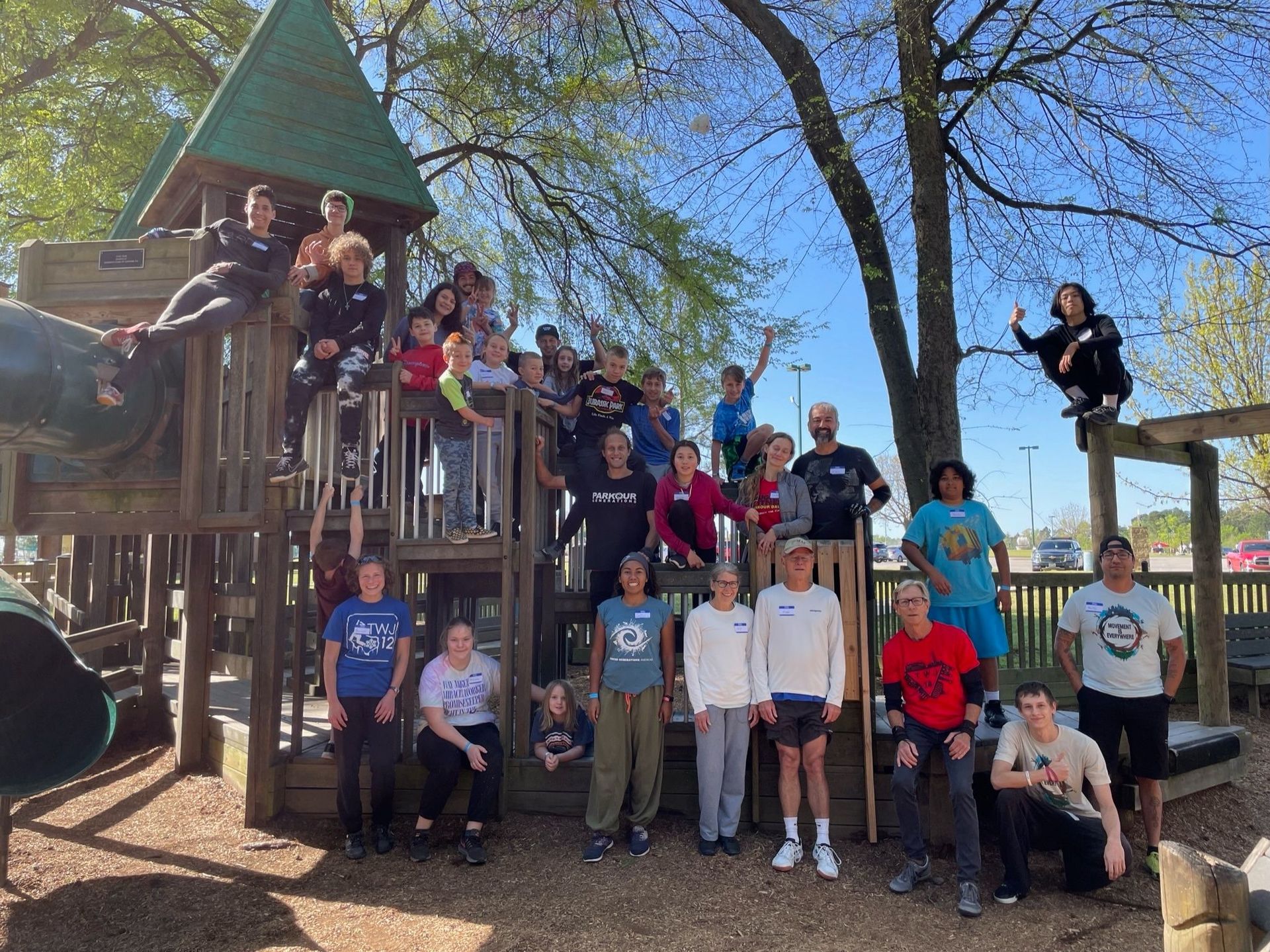 A group of people are posing for a picture in front of a playground.