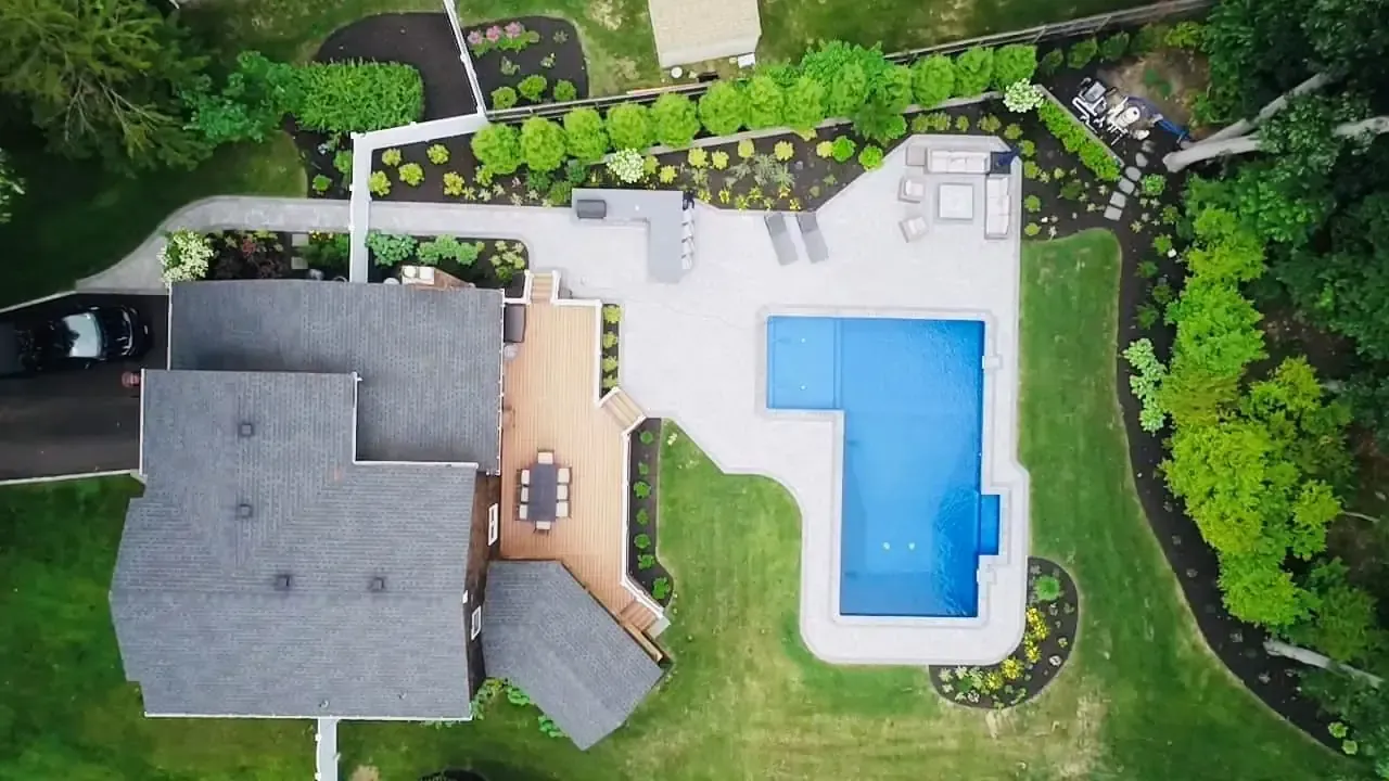 An aerial view of a house with a large pool in the backyard.