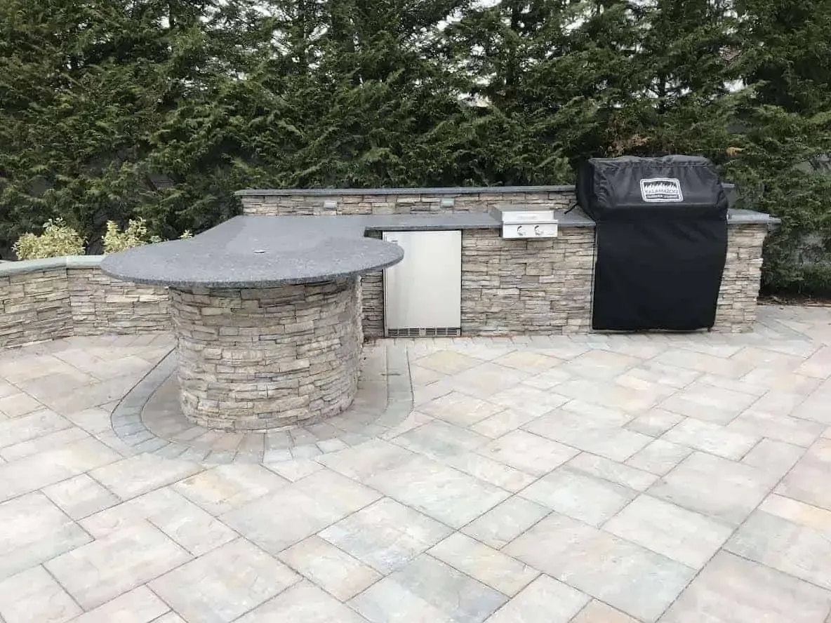 There is a grill and a table on the patio.