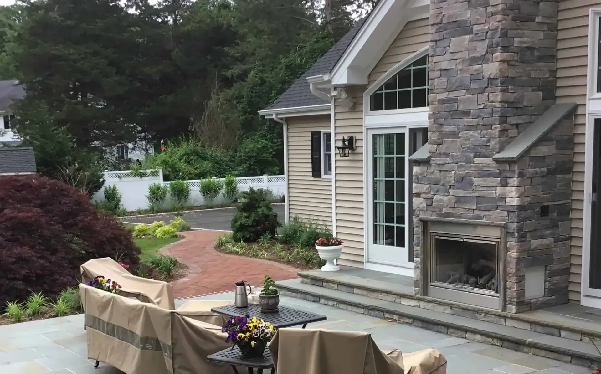 There is a fireplace in the backyard of a house.