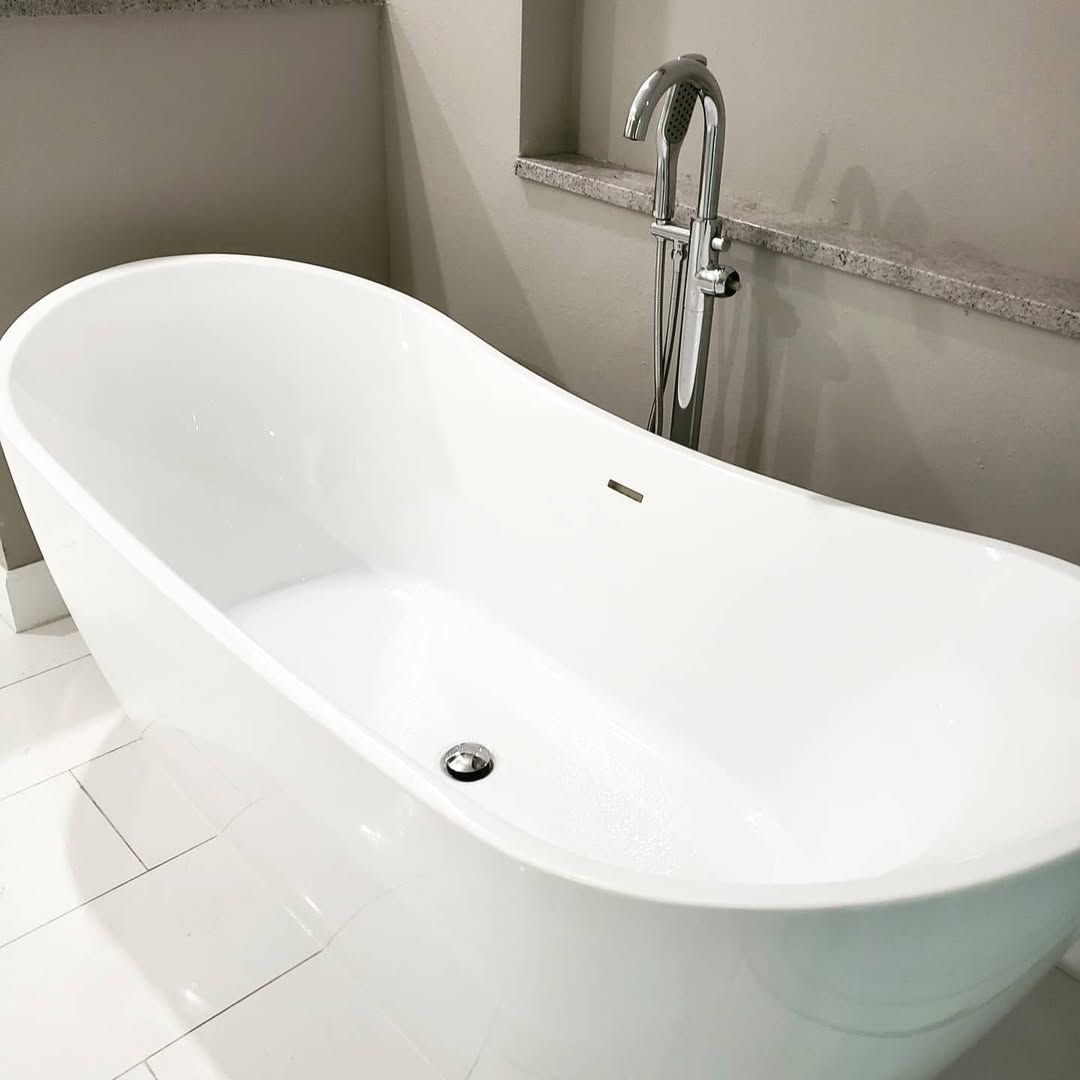 Plumber fixing a sink faucet in a bathroom, using a wrench and other tools.