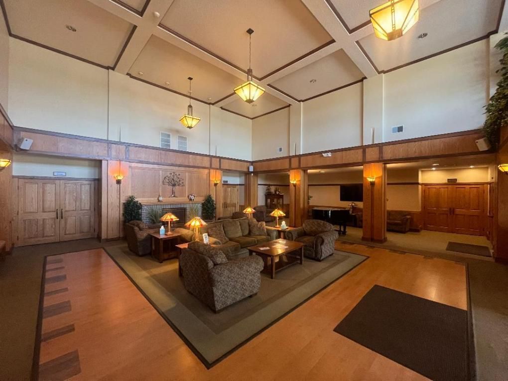 The front door of a house with a porch and plants in front of it.