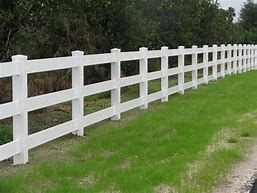 A black metal fence surrounds a lush green yard.
