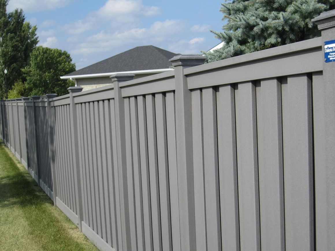 A gray fence with a blue sign that says e on it