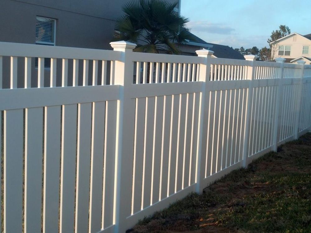 A white fence with a palm tree in the background