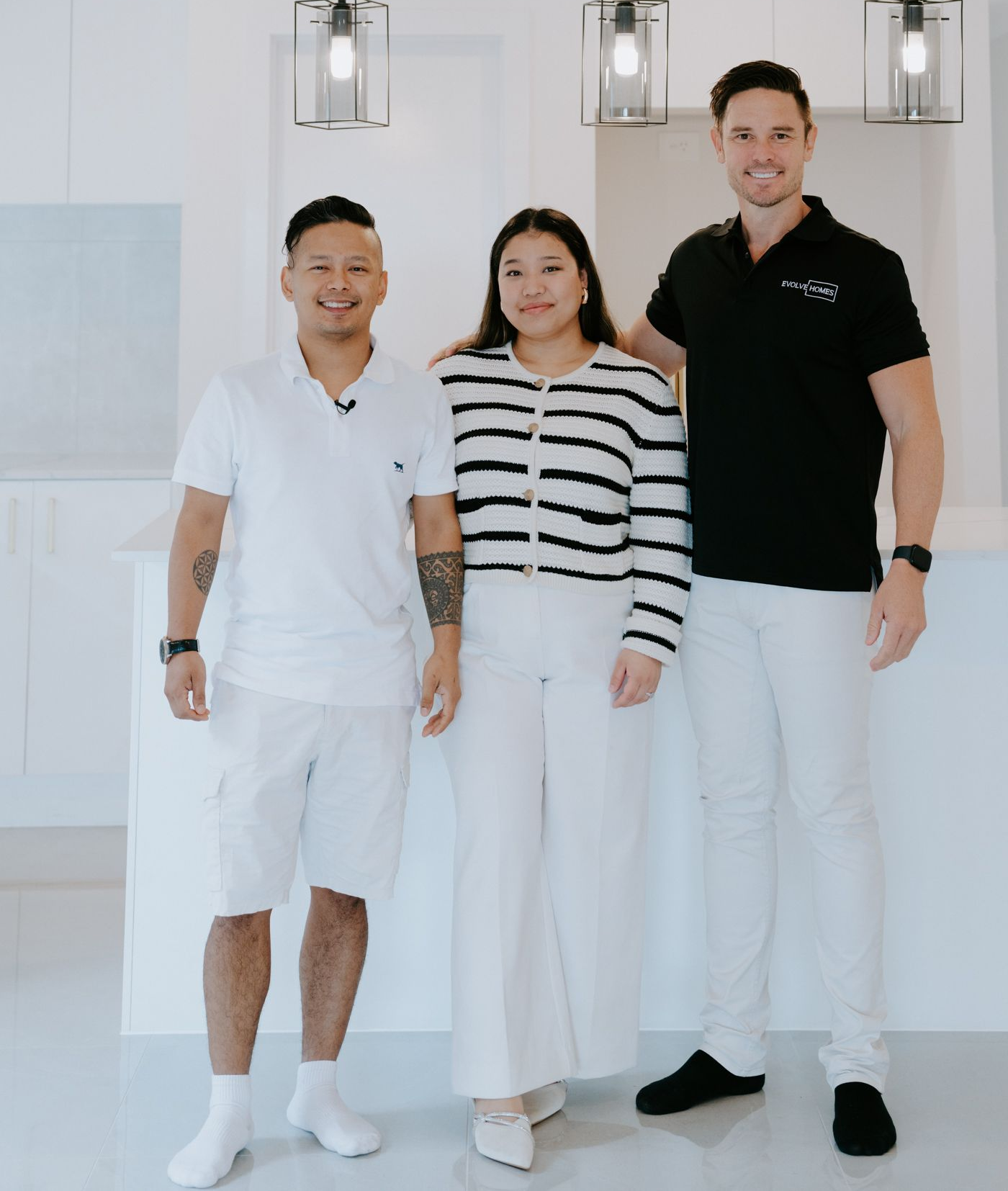Single-story house with a white roof, gray siding, brown garage door, and a stone walkway.