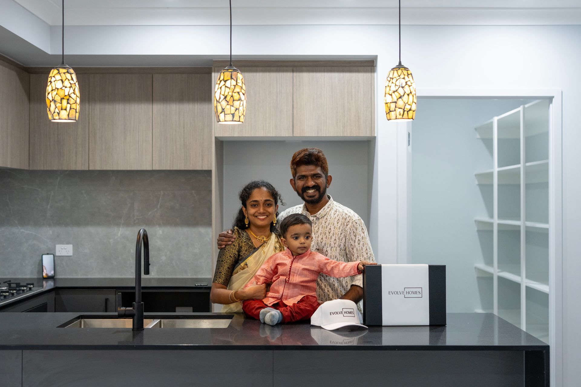 Modern beige house with a driveway, garage, and front yard landscaping.