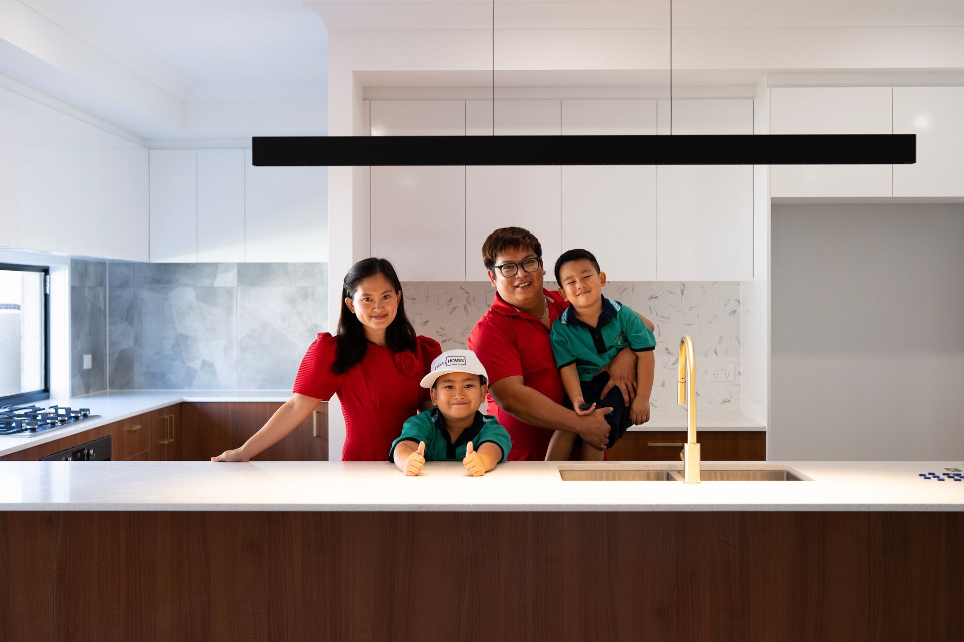 Single-story house with a white roof, gray siding, brown garage door, and a stone walkway.