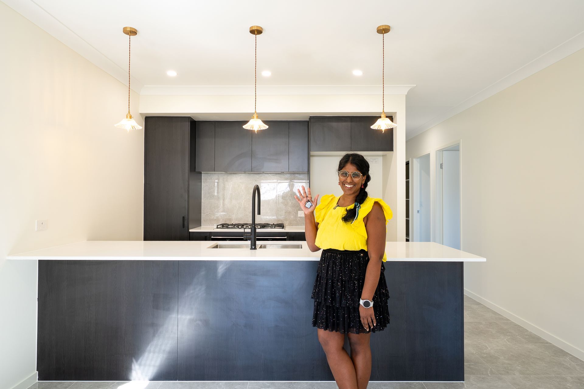 Modern beige house with a driveway, garage, and front yard landscaping.