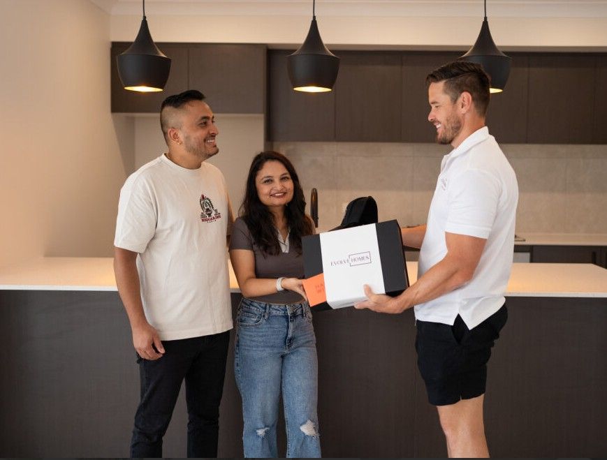 Modern beige house with a driveway, garage, and front yard landscaping.