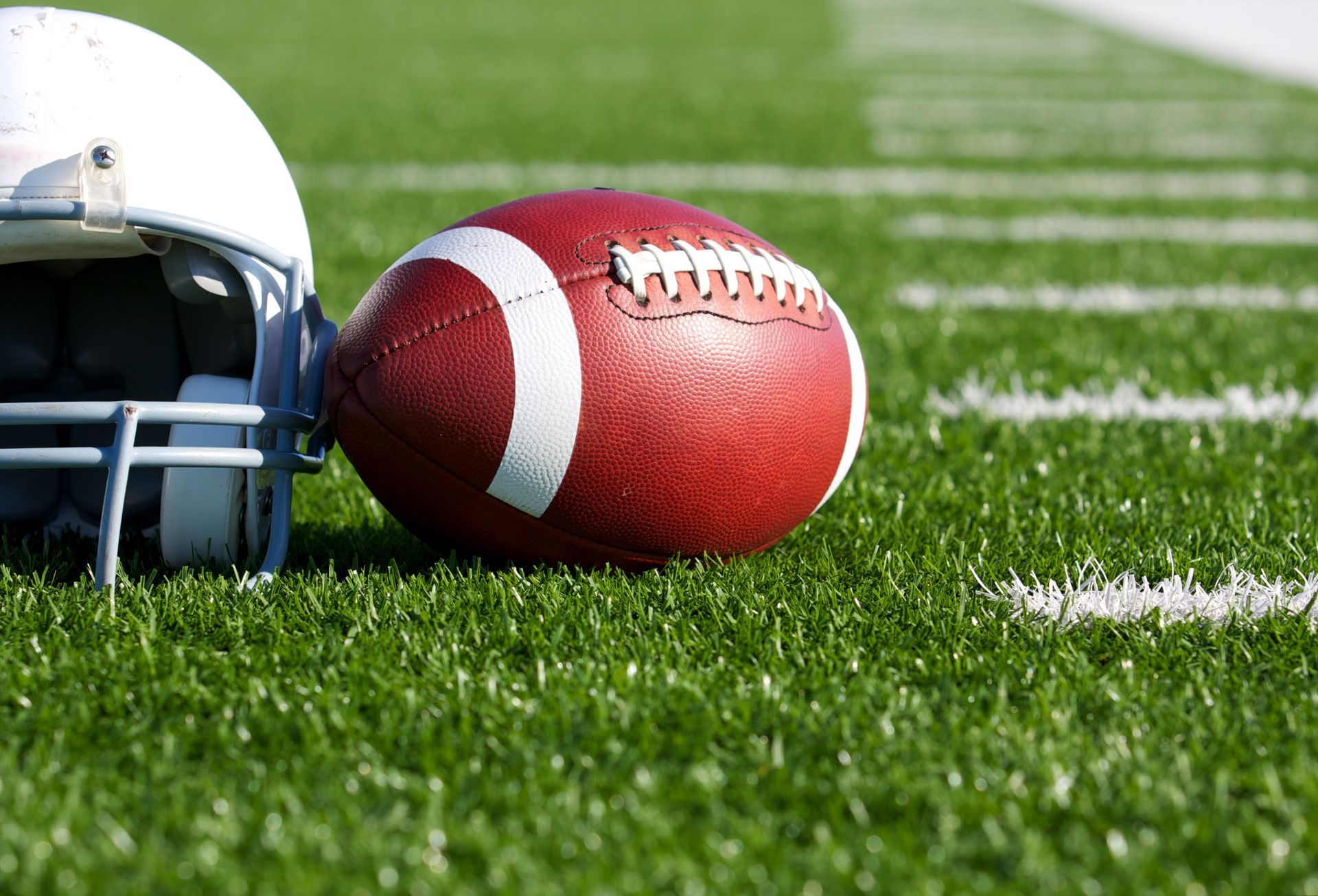 football and helmet on grassy field