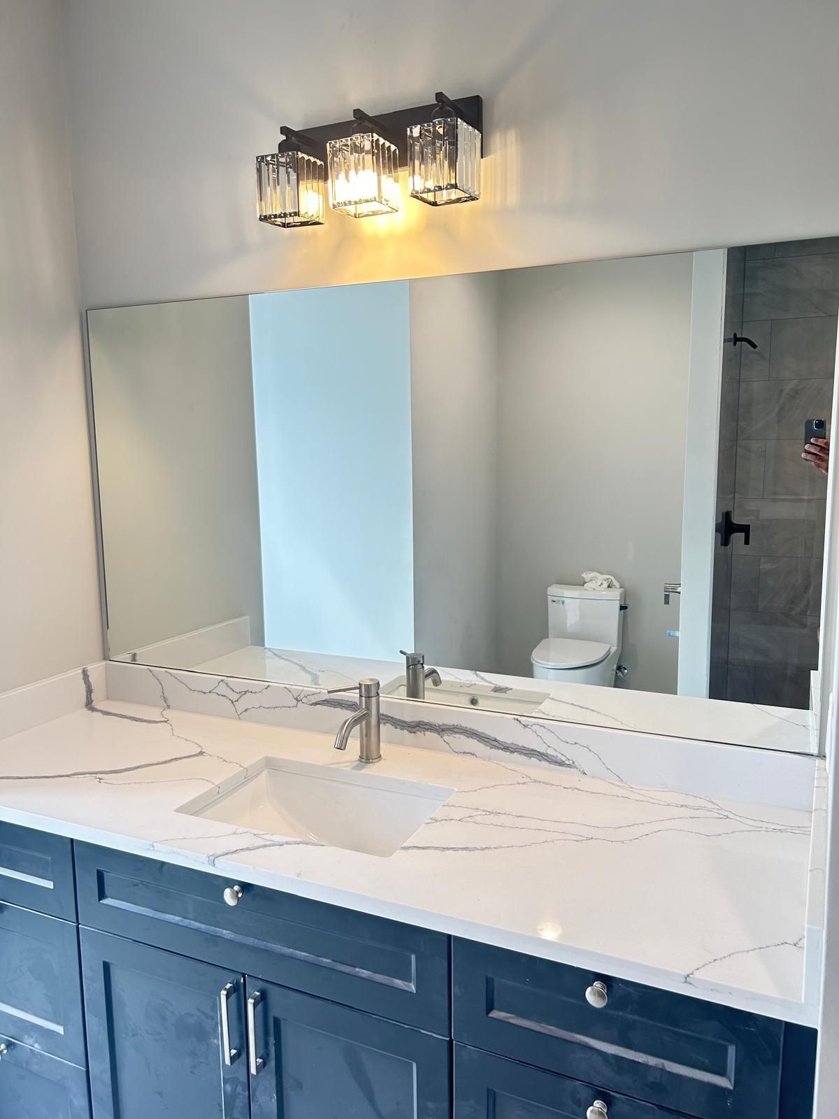 Mirror mounted on the wall in a bright bathroom setting.