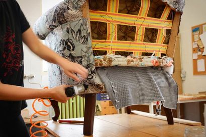 A Person is Working on a Chair With a Pneumatic Tool — Custom Unique Trimming in Mackay, QLD