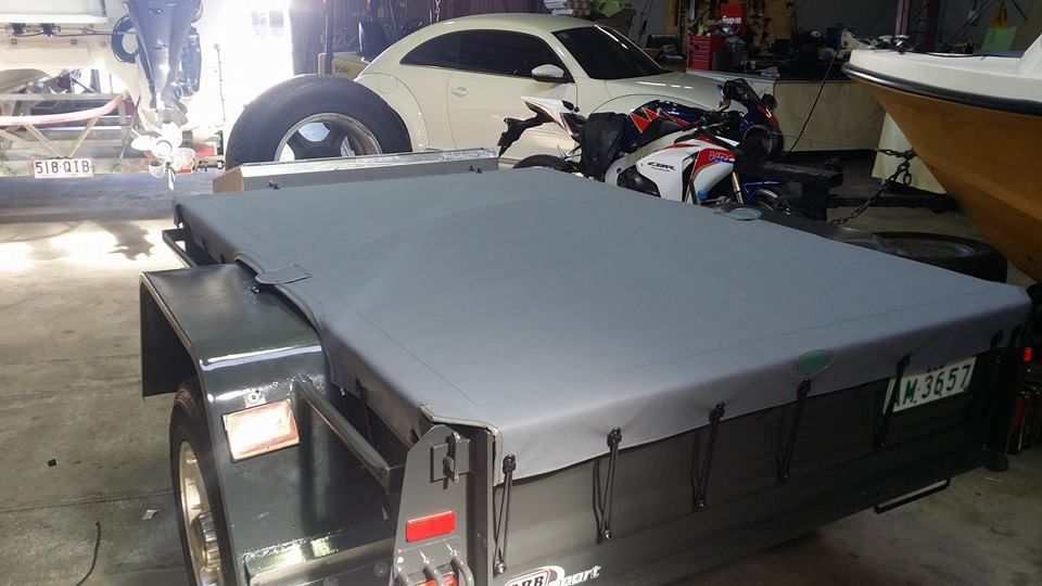 A Trailer With a Tarp on It is Parked in a Garage Next to a Car and Motorcycle — Custom Unique Trimming in Mackay, QLD