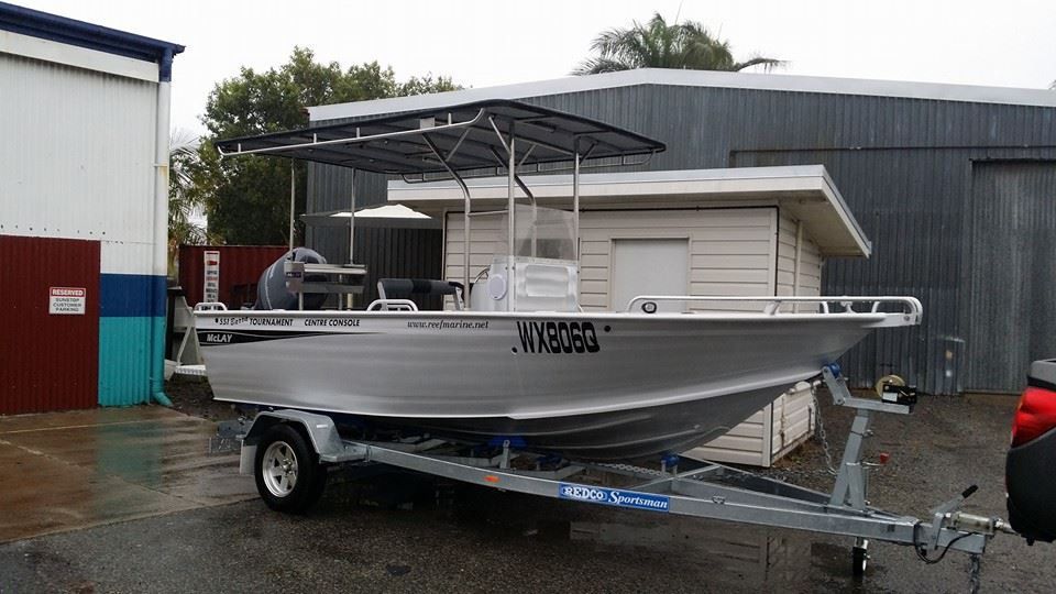 A Boat is on a Trailer in Front of a Building — Custom Unique Trimming in Mackay, QLD