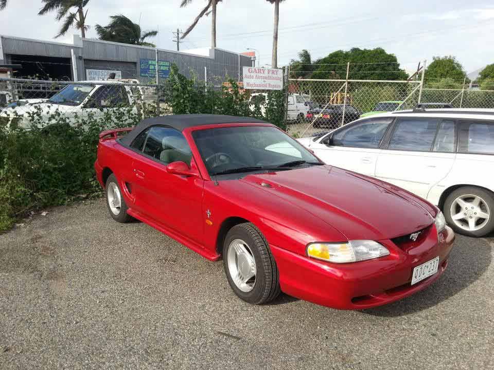 A Red Mustang Convertible is Parked in a Parking Lot — Custom Unique Trimming in Mackay, QLD