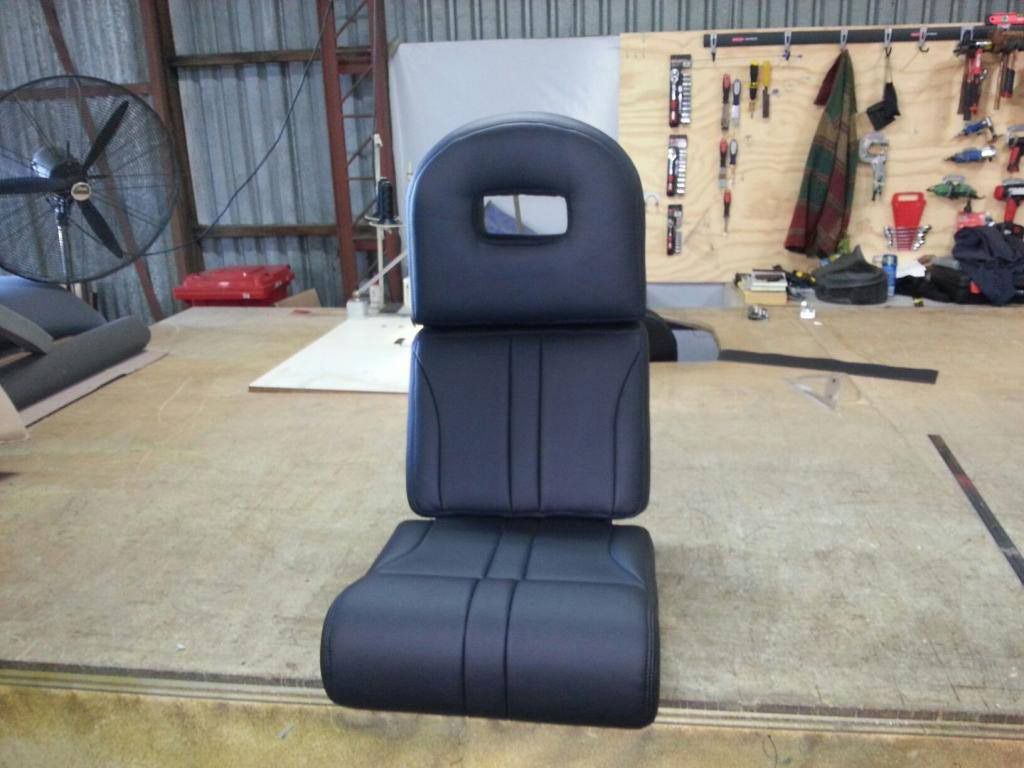 A Black Chair With a Hole in the Back Sits on a Stage — Custom Unique Trimming in Mackay, QLD