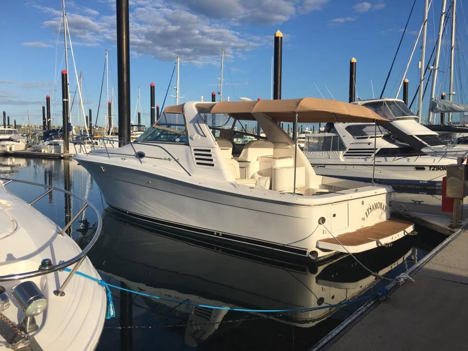 A White Boat With a Tan Canopy is Docked at a Marina — Custom Unique Trimming in Mackay, QLD