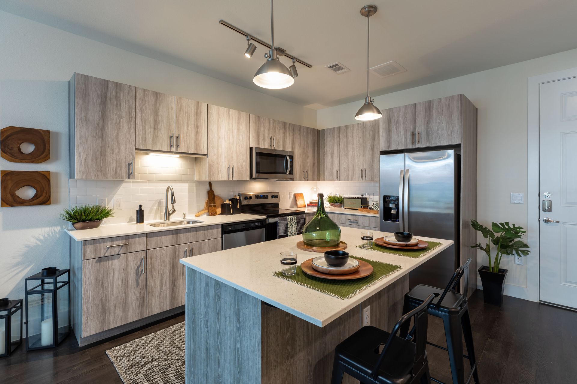 A kitchen with wooden cabinets , stainless steel appliances , and a large island.