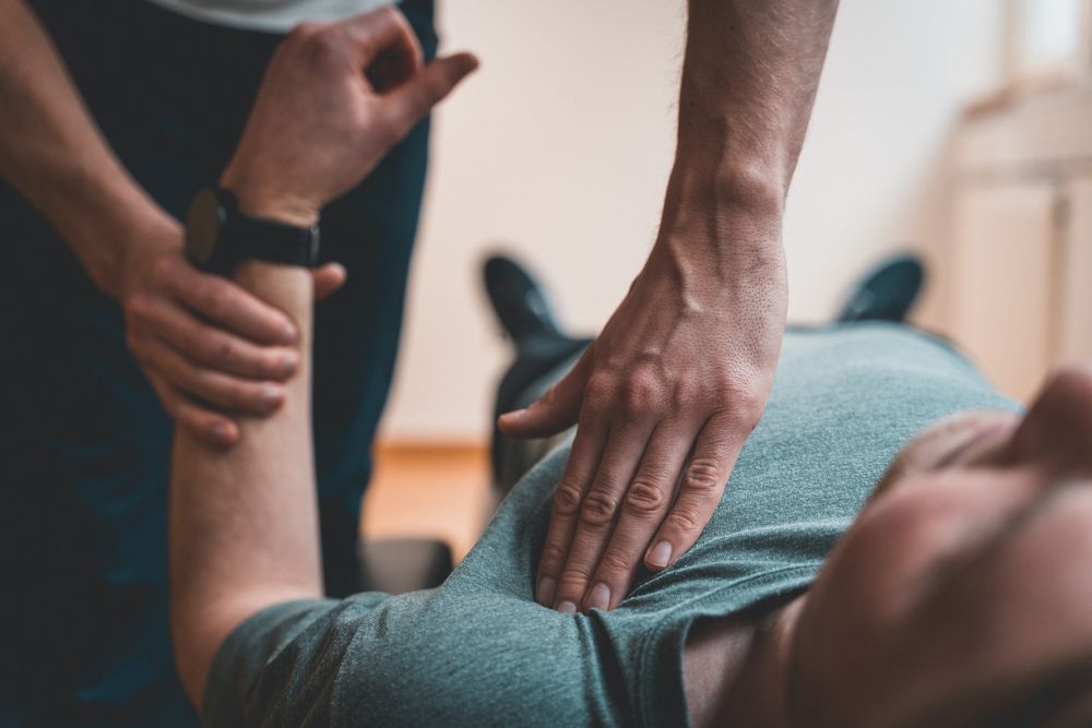 Person receiving shoulder physical therapy from another person, indoors. — Bourbong Street Physiotherapy Centre in Bundaberg West, QLD