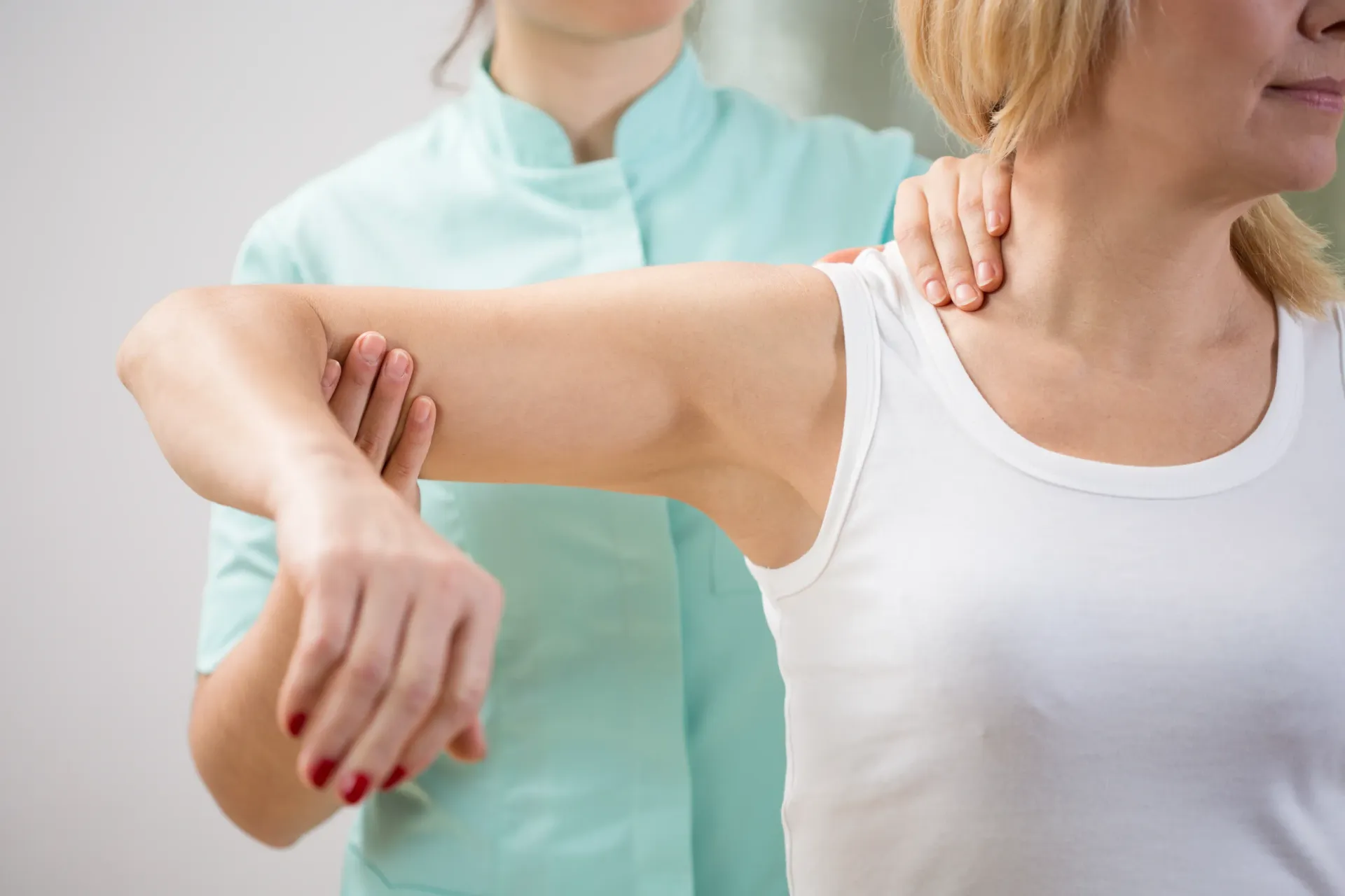 Woman receiving physical therapy, shoulder and arm being manipulated by therapist. — Bourbong Street Physiotherapy Centre in Bundaberg West, QLD