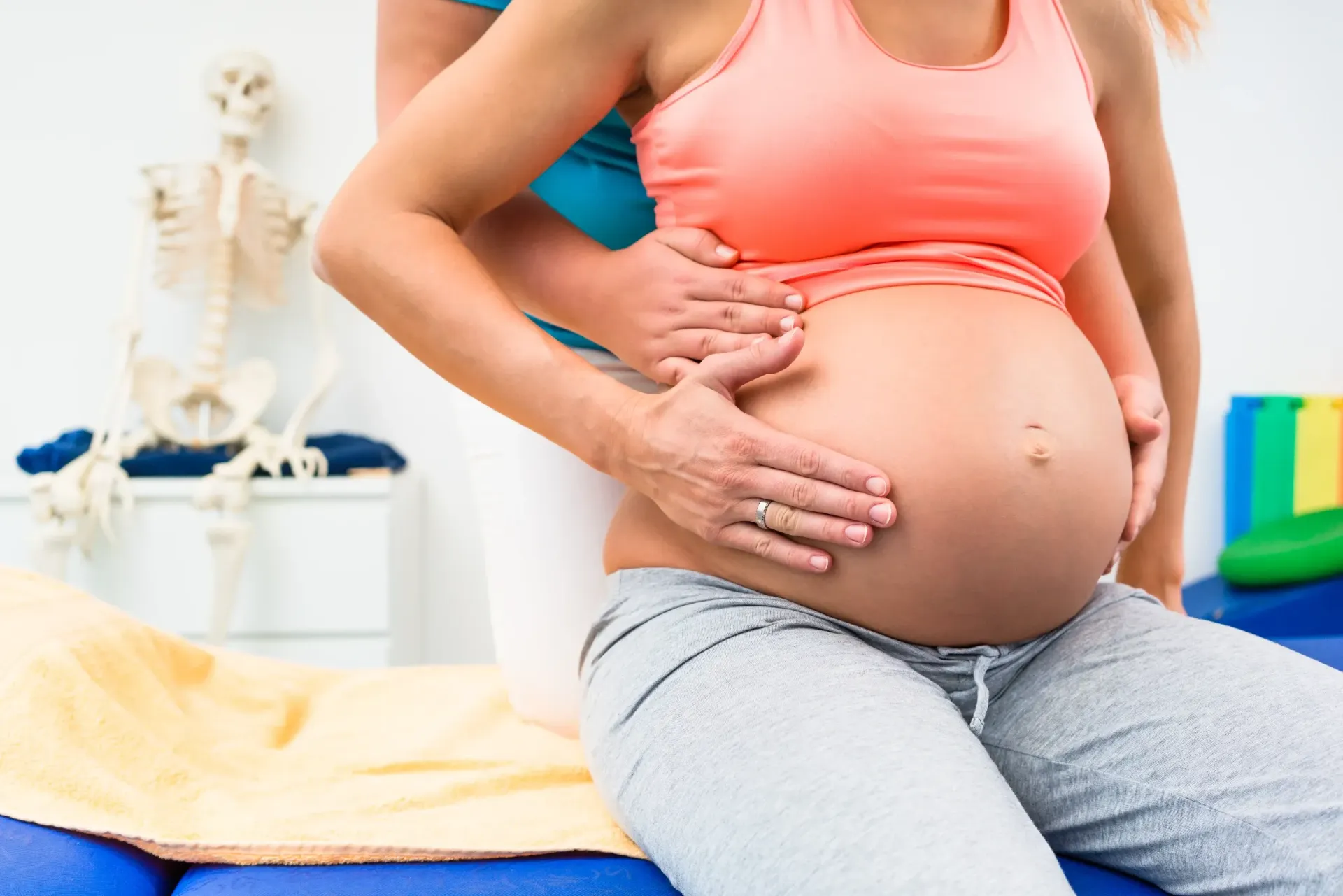 Pregnant person receiving abdominal massage from another person in a clinic. — Bourbong Street Physiotherapy Centre in Bundaberg West, QLD