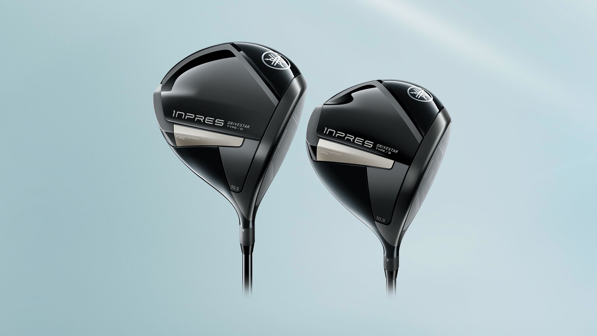 Two black golf clubs are sitting next to each other on a blue surface.