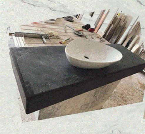 In un ambiente adibito a officina, un lavabo ovale bianco è posizionato su un piano di lavoro rettangolare in pietra scura e ruvida.