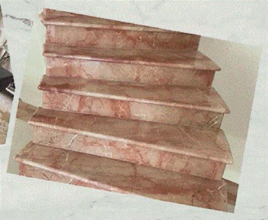 Una scalinata di quattro gradini in marmo con venature di colore bruno-rossastro, vista da un'angolazione leggermente dall'alto.