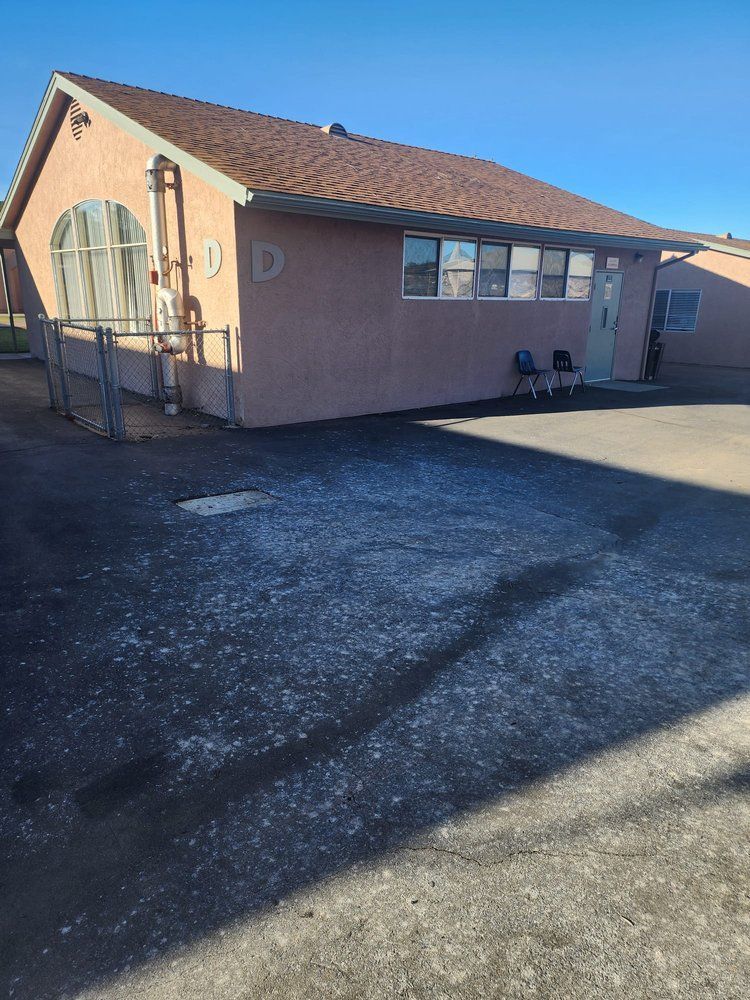 A small house with a lot of windows and a fence in front of it.
