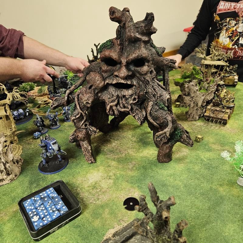 A group of people are playing a game with a tree with a face on it.