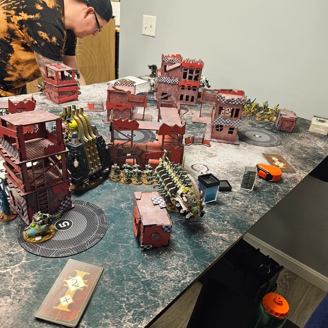 A man is playing a game of warhammer on a table