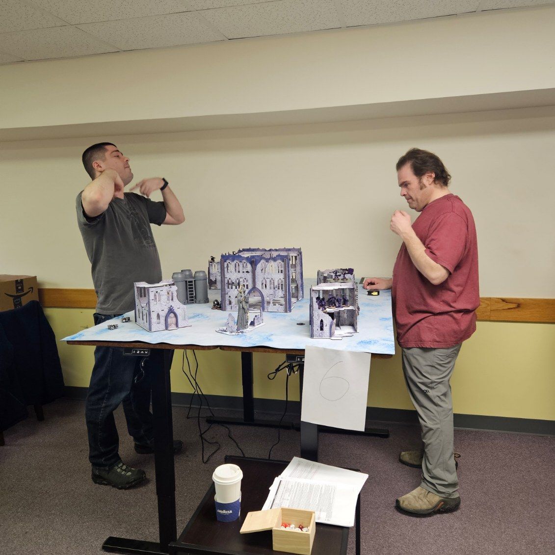 Two men standing in front of a table with boxes on it