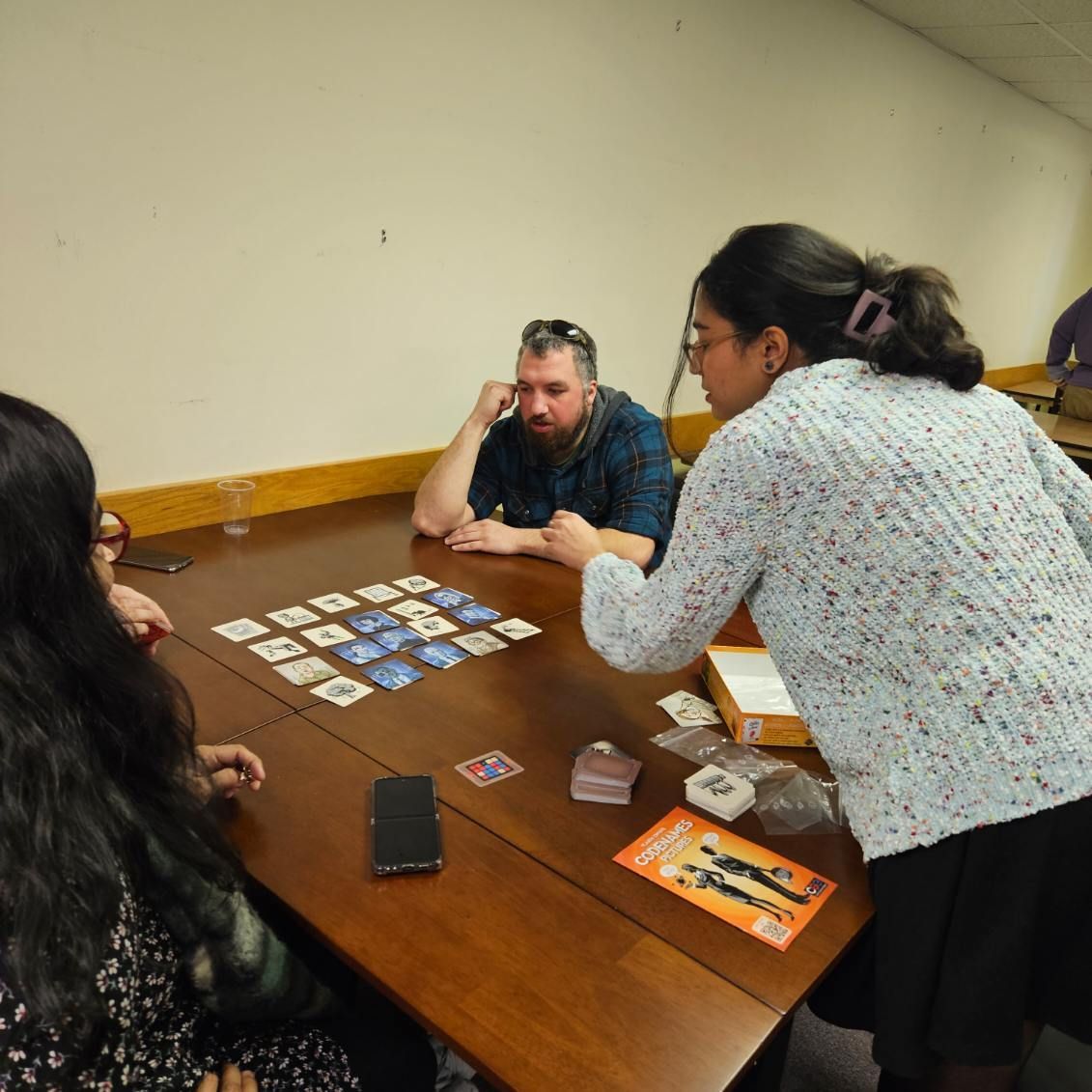 A group of people are sitting around a table playing a game