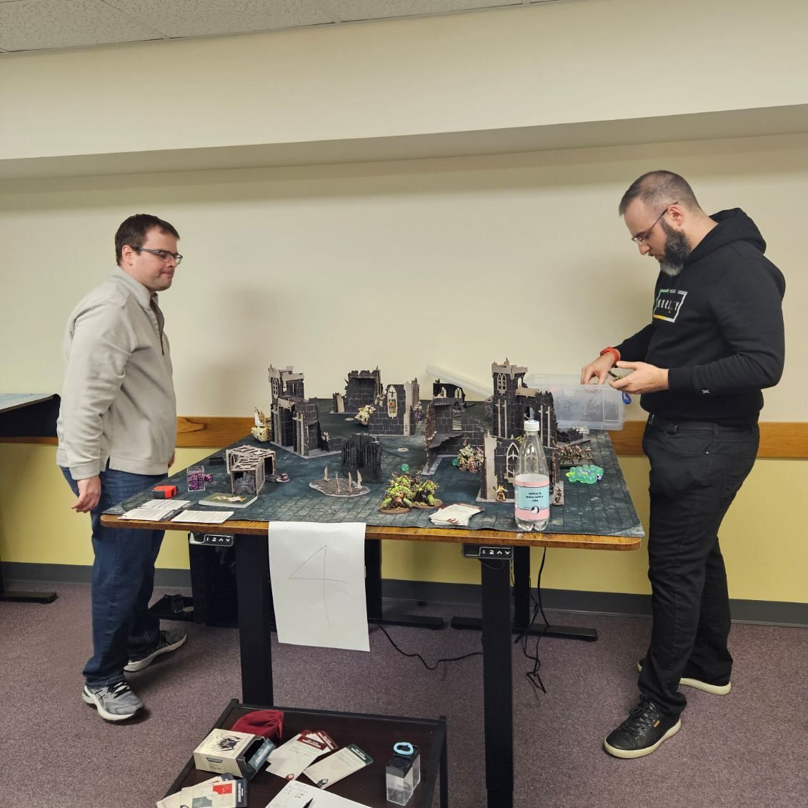 Two men are standing in front of a table with toys on it