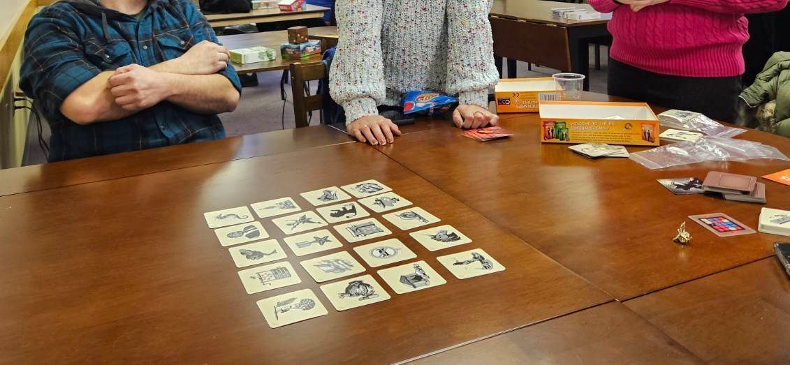 A group of people are sitting at a table playing a game of cards.
