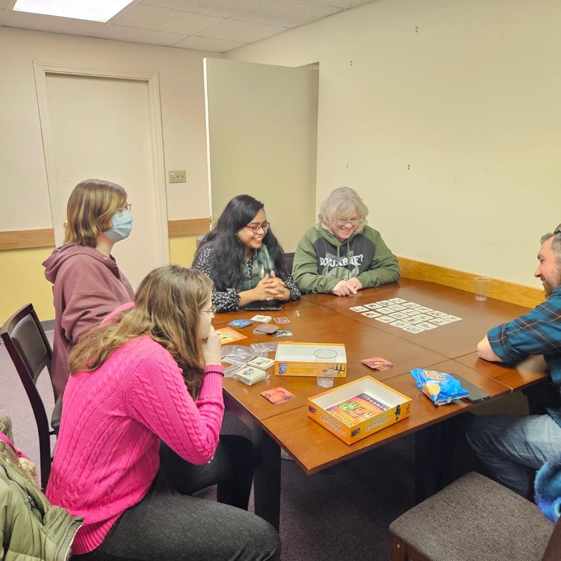 A group of people are sitting around a table playing a game.